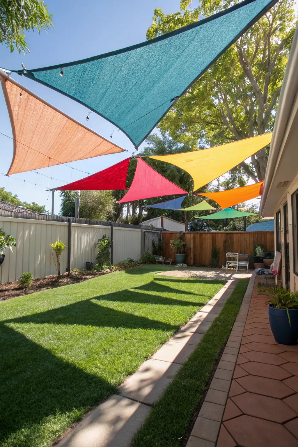 Triangular sail shades in a mix of bold colors creating a vibrant backyard canopy.