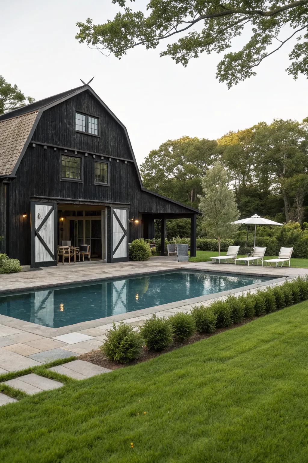 A black barn with a luxurious courtyard pool.