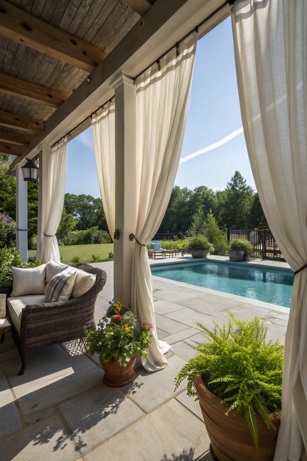 Elegant outdoor curtains providing privacy on a poolside porch.