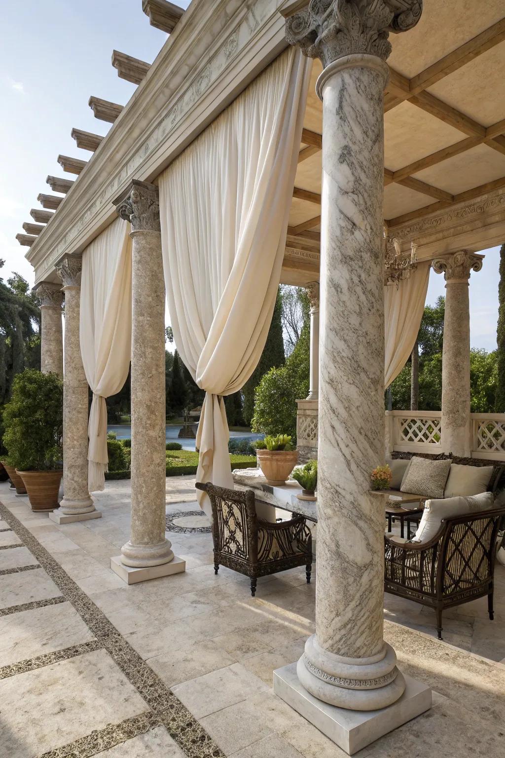 Marble columns and a fabric canopy create a luxurious outdoor space.
