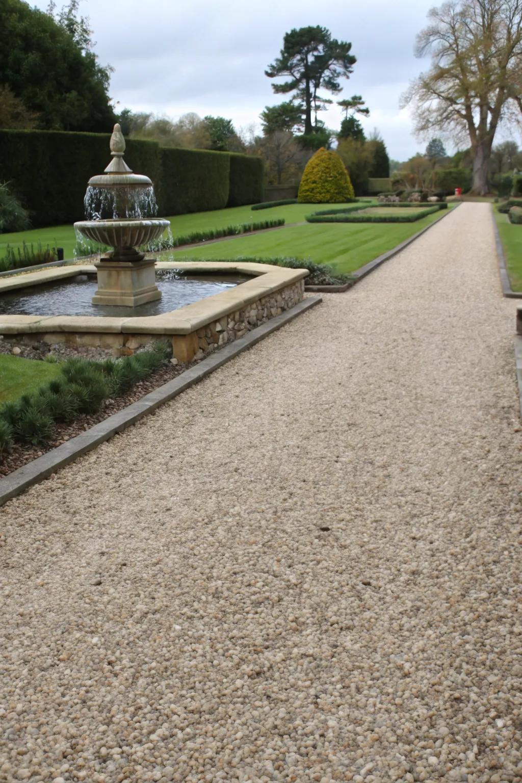 A gravel driveway enhanced with a tranquil water feature.
