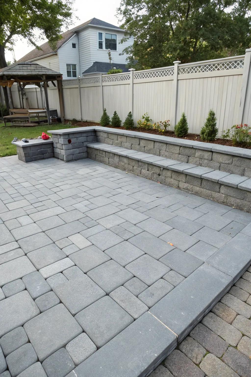 Built-in bench seating offers ample gathering space on a gray paver patio.