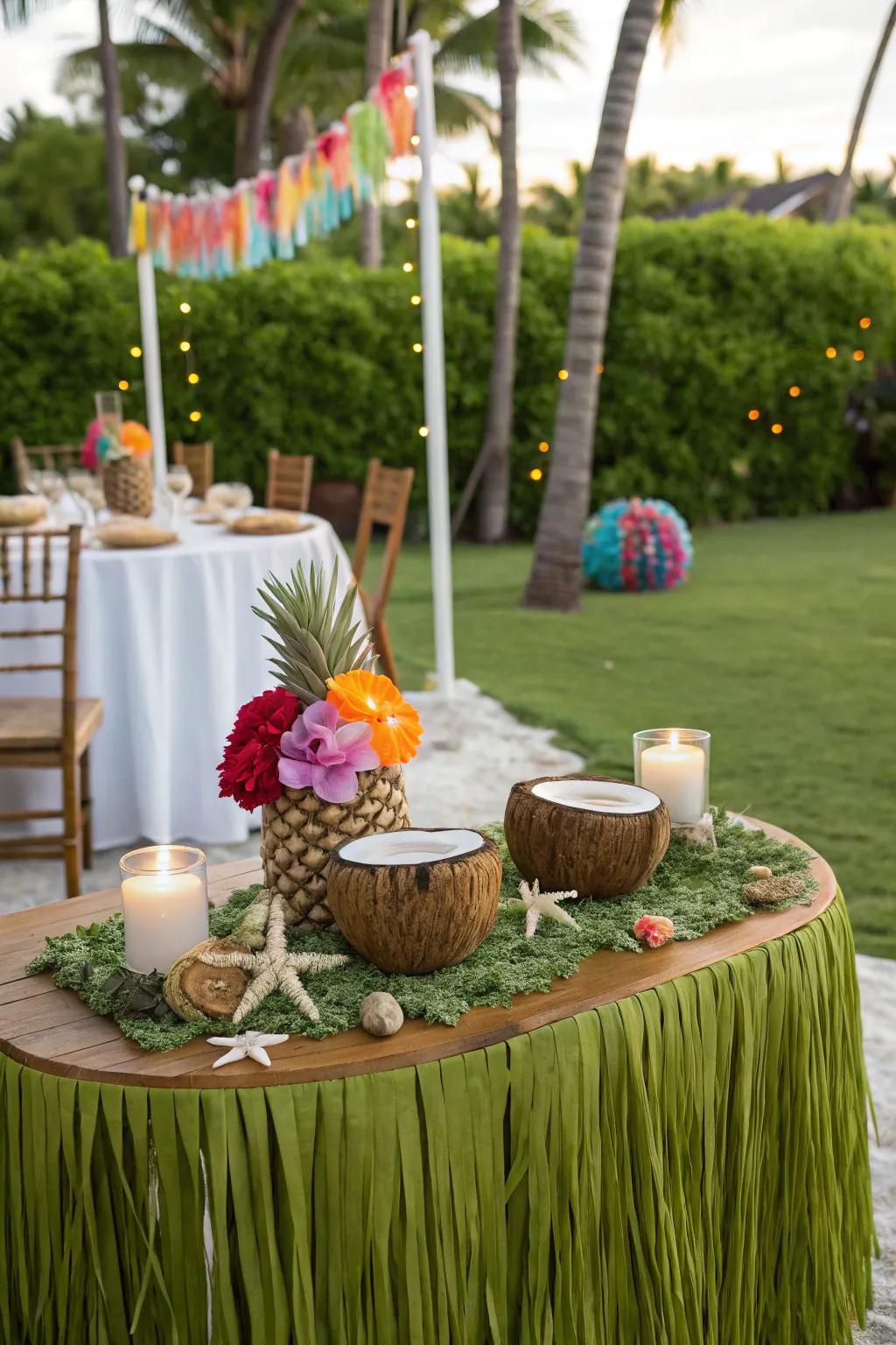 Outdoor table with tropical decor like grass skirts, seashell centerpieces, and coconut shell candles.