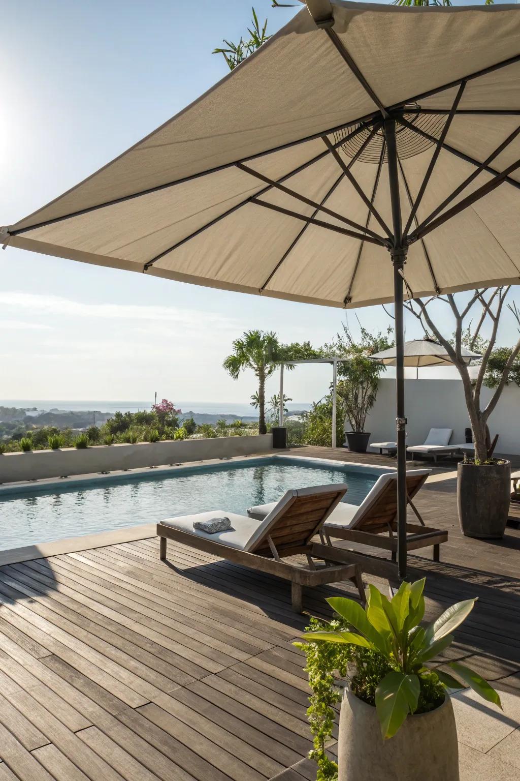A pool deck lounge area shaded by a large umbrella.