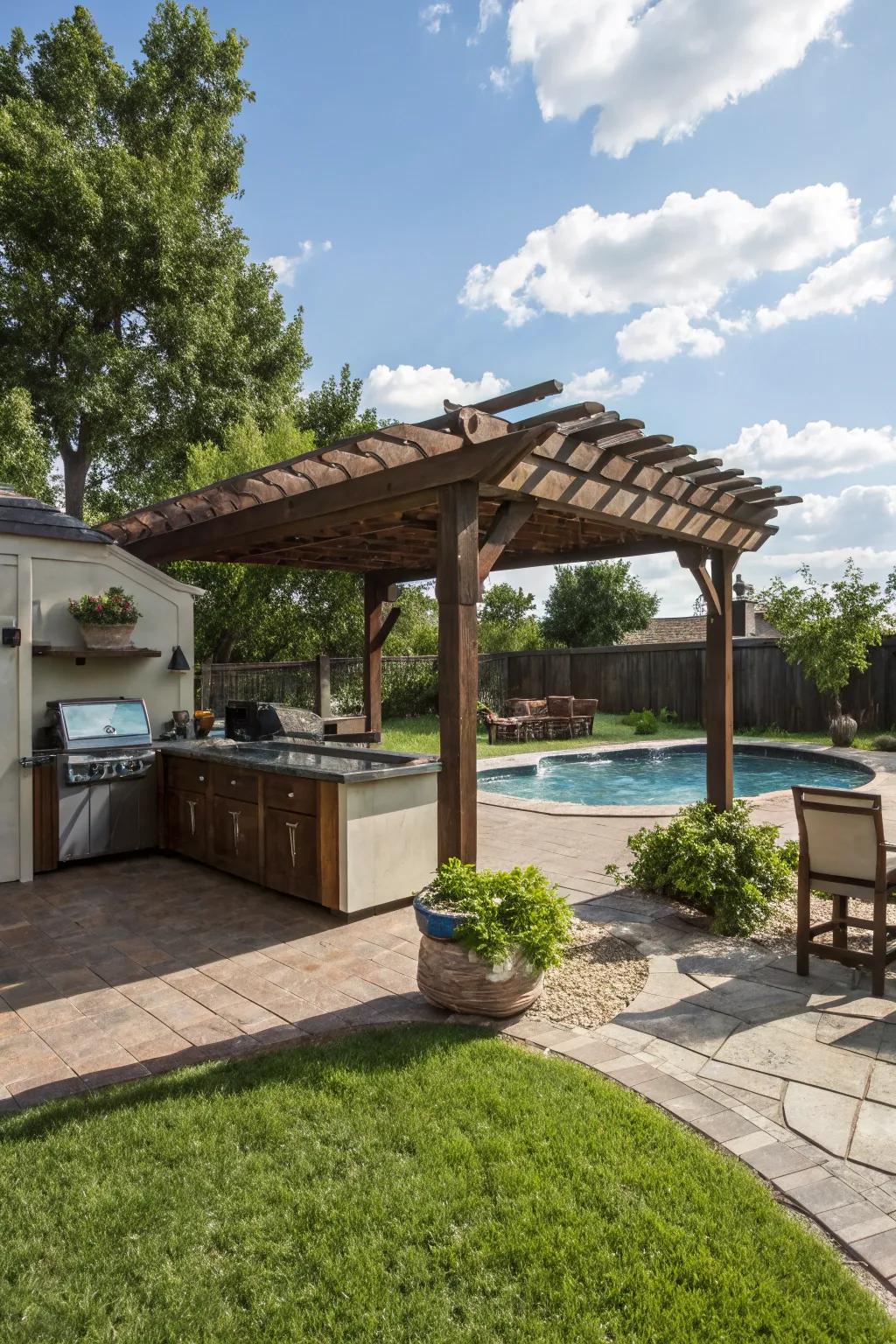 A pergola adds charm and shade to this outdoor kitchen and pool area.