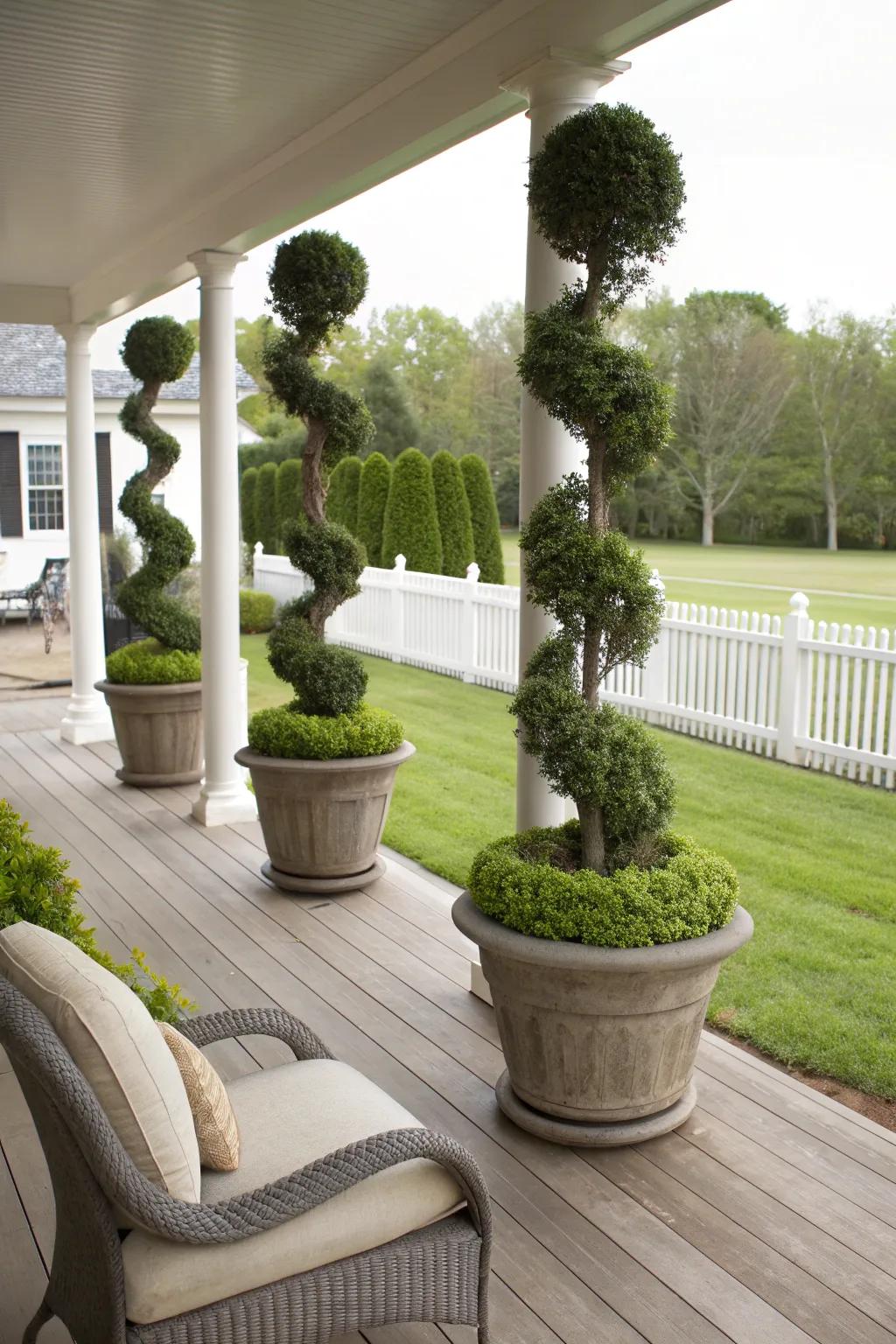 Sophisticated spiral topiary trees enhance the porch's elegance.