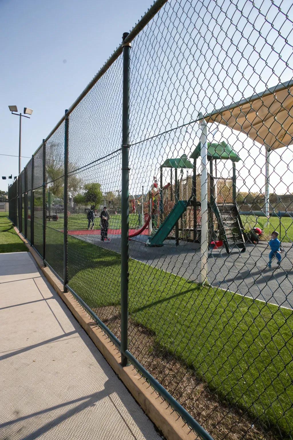 Mesh fencing allows for clear visibility while keeping the playground secure.