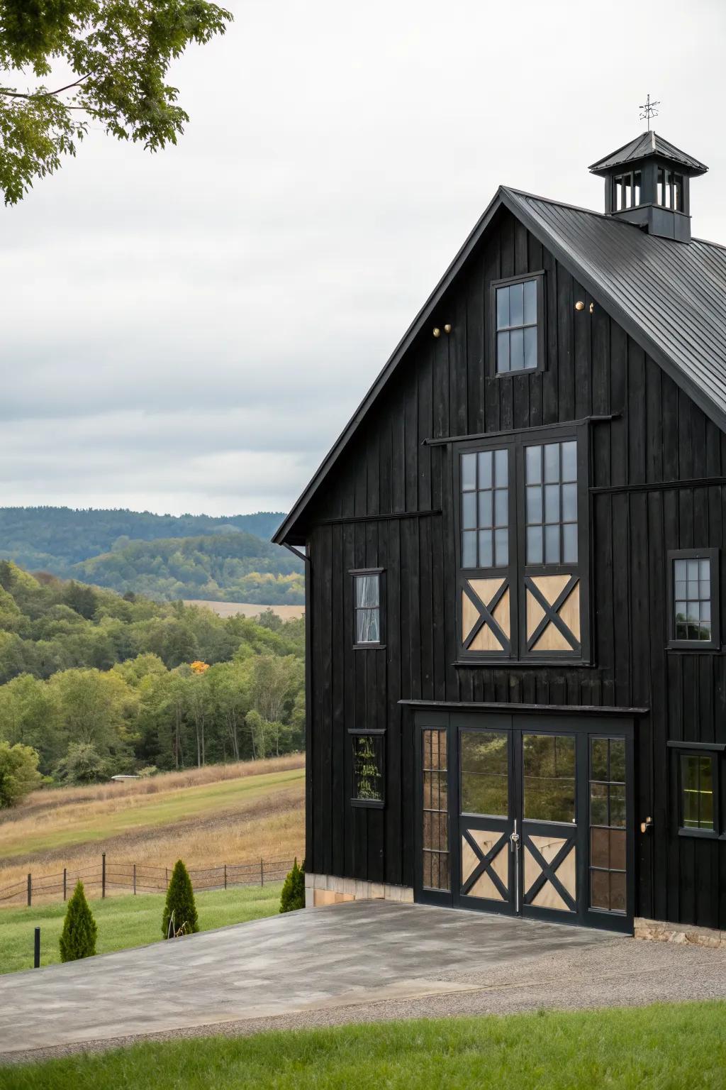 A black barn featuring large, unique windows and doors.