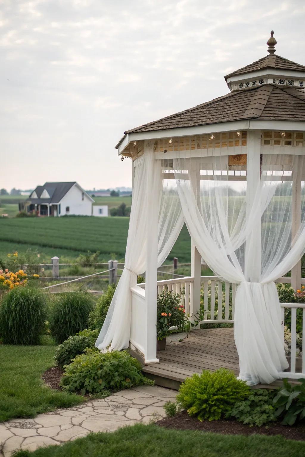 Sheer curtains add a touch of elegance and privacy to this farmhouse gazebo.