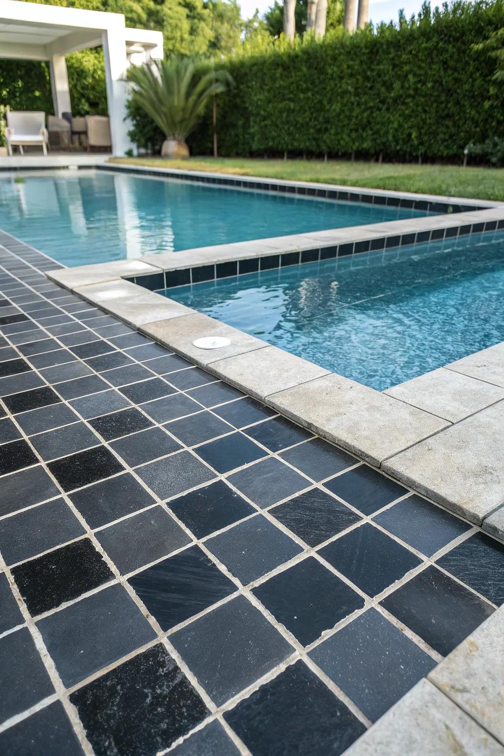 A striking pool with bold black mosaic tiles.