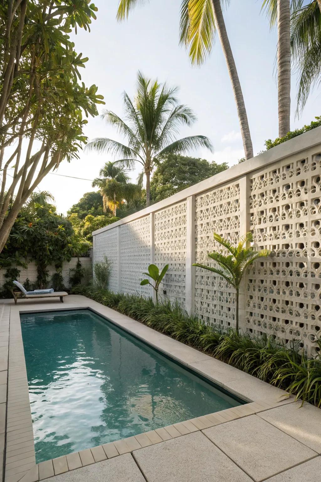 A luxurious pool area with a breeze block privacy wall