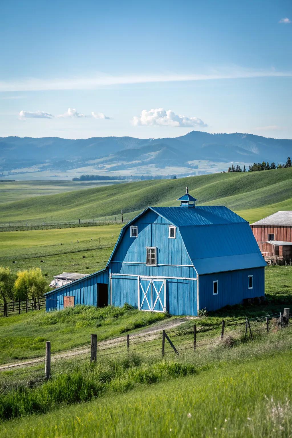 A striking blue barn set against a clear sky and verdant countryside.