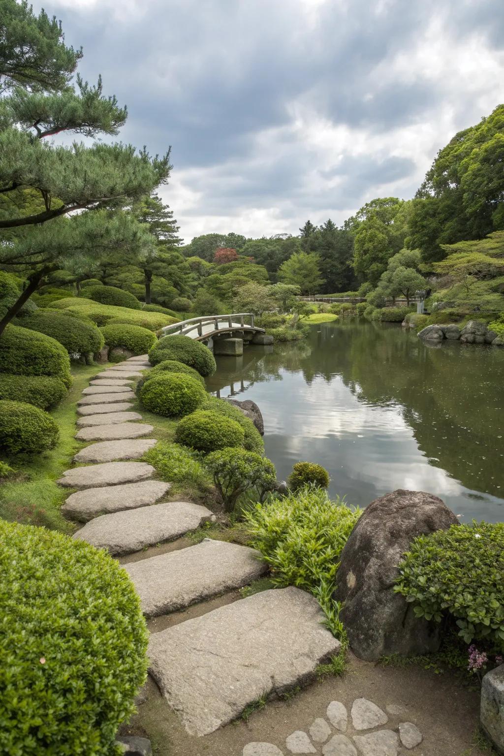 Path in a Japanese garden running alongside a serene pond, offering a tranquil walking experience.